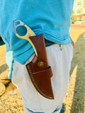 Damascus knife inside leather sheath held as camping gear