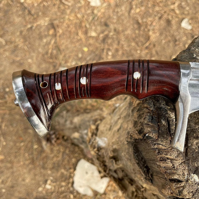 Wooden-handled knife with metal blade on a rocky surface with perfect texture and design