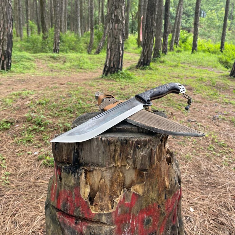 Large knife on a tree stump in a forest used for camping and survival.