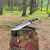 Large knife on a tree stump in a forest used for camping and survival.