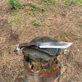 Gurkha Knife with a wooden handle on a tree stump in an outdoor adventure and camping