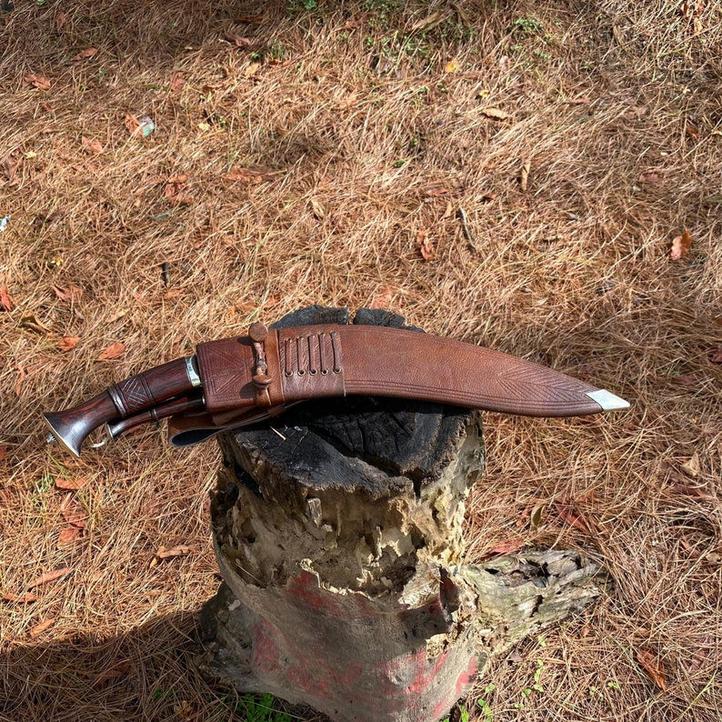 Traditional knife with sheath on a wooden stump outdoors