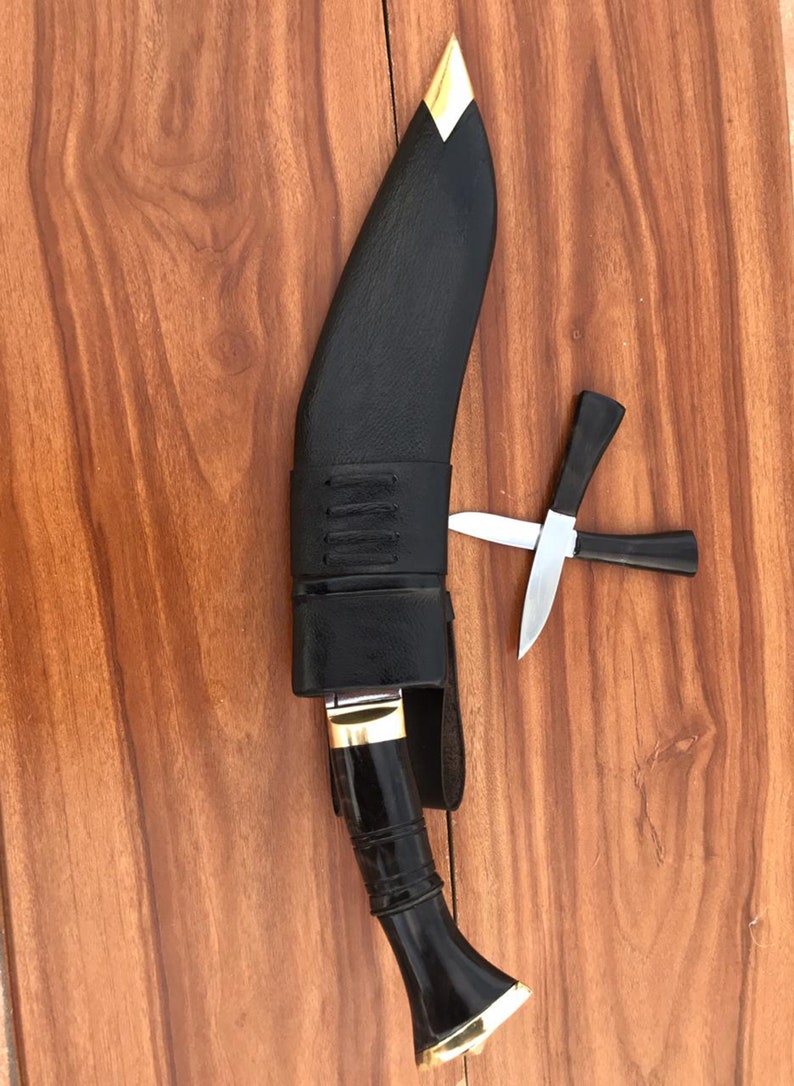 Black kukri knife with sheath on a wooden surface
