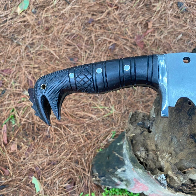 Close-up of a black-handled machete knife on a natural background