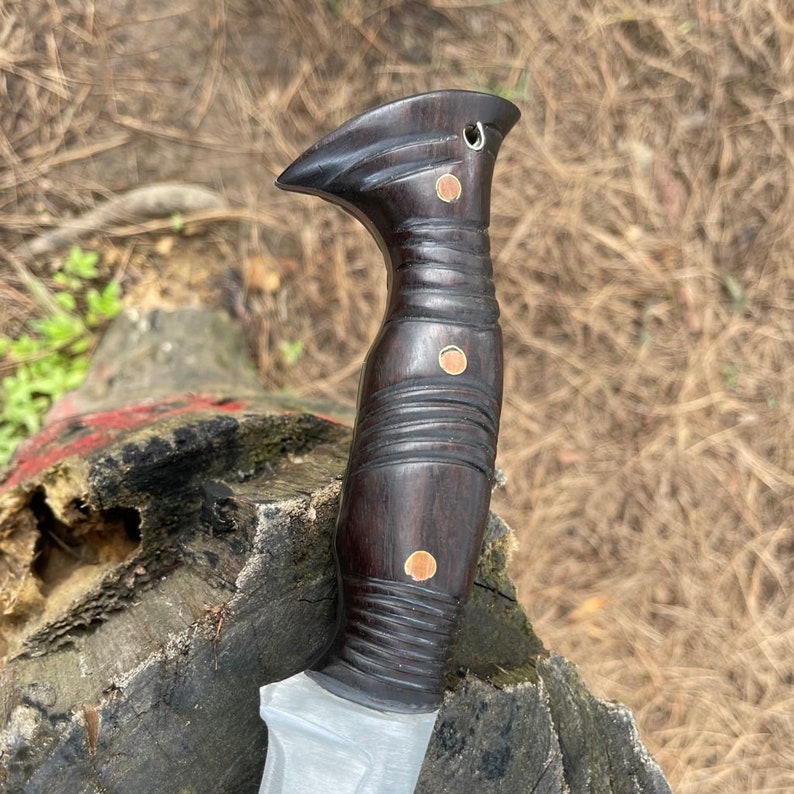 Wooden handled knife close up look with a textured grip on a natural background