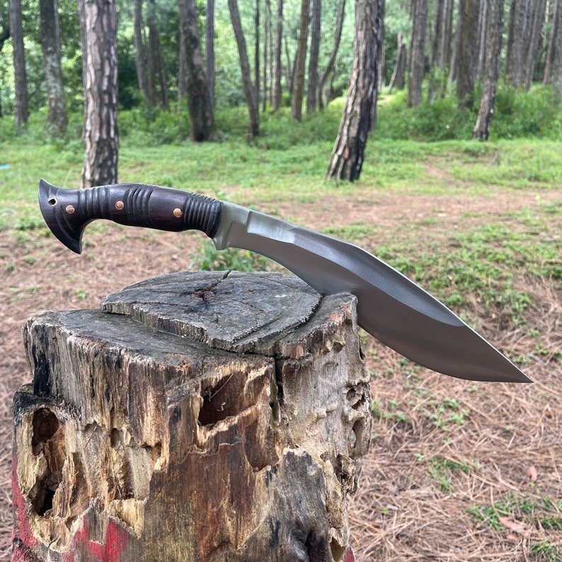 Kukri knife on a wooden stump in a forest background power testing and durability