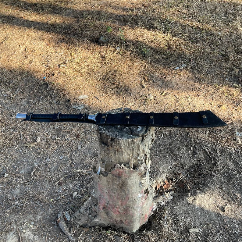Machete blade with black leather handle inside its leather cover with premium look and classic shine