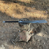 Shining long metal machete sword on a log with a natural outdoor used for camping and protection and wildlife