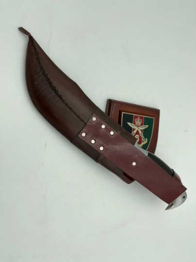 A 10 inch hand forged Bowie knife with a black and gray blade and a brown rosewood handle, displayed next to its scabbard.