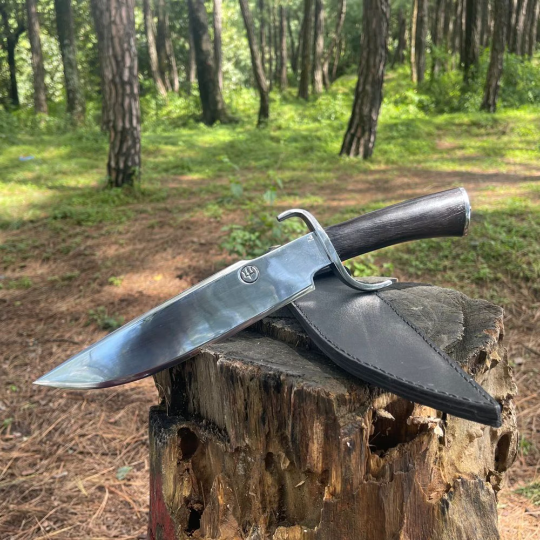 Hand-forged bowie khukuri knife blade displayed with sheath