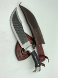 A 10 inch hand forged Bowie knife with a black and gray blade and a brown rosewood handle, displayed next to its scabbard.