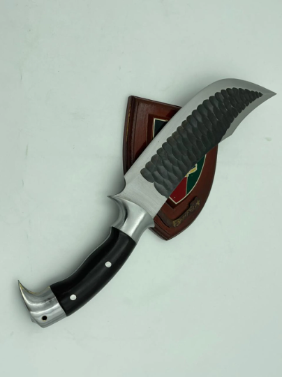 A 10 inch hand forged Bowie knife with a black and gray blade and a brown rosewood handle, displayed next to its scabbard.