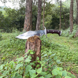 Tikau Kukri knife chopping wood outdoors, showcasing its survival and hunting capability
