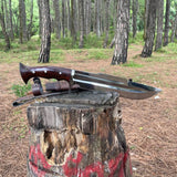 Long knife with wooden handle on a tree stump in a forest setting