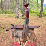 Decorative dagger with sheath on a wooden stump in a forest setting