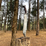 Shining blade knife on a wooden stump in a forest for camping and protection