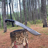 Machete Knife with a black handle on a tree stump in a forest for camping and protection
