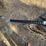 Black handled machete knife with leather strap in log close look detailed