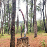 Decorative knife and sheath on a wooden stump in a forest setting