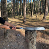 Person holding a machete over a log in a forest used for camping and protection and widlife