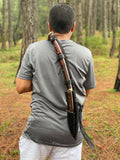 Person in a forest holding a khukuri knife set on their back