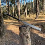 Machete sword embeded on a wooden stump in a forest  showcase 