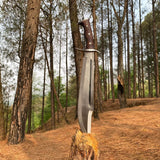 Large knife with a wooden handle on a log in a forest setting