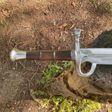 Sword with wooden handle and metal blade on a natural background  