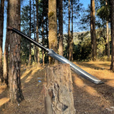 Sword embedded in a tree stump in a forest setting used for survival