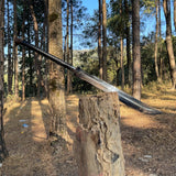 Viking sword drawn halfway from leather scabbard, showcasing refined handle and traditional gawa craftsmanship