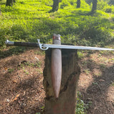 Sword embedded in a tree stump with a forest background 
Survival machete-style sword shown next to outdoor gear