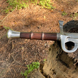 Decorative sword with wooden handle and silver blade on a natural background