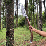 Person holding a large axe in a forest setting