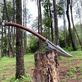 Long axe with a wooden handle on a tree stump in a forest setting