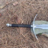 Sword with a black handle on dry grass