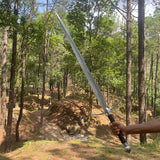 Person holding a large sword in a forest setting