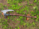 Tactical axe with a wooden handle on grass
