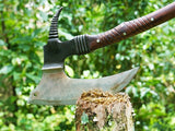 Decorative axe with a wooden handle on a stump against a green forest background